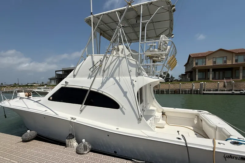 Slide: The Image of 2004 Luhrs 36 Convertible yacht docked at marina, clear sky background. - 2