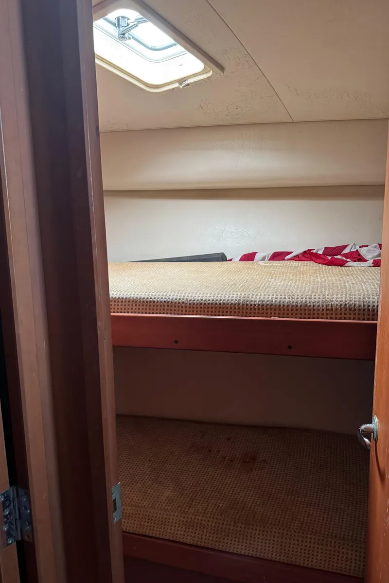 Slide: The Image of 2004 Luhrs 36 Convertible cabin with bunk beds and overhead hatch. - 23