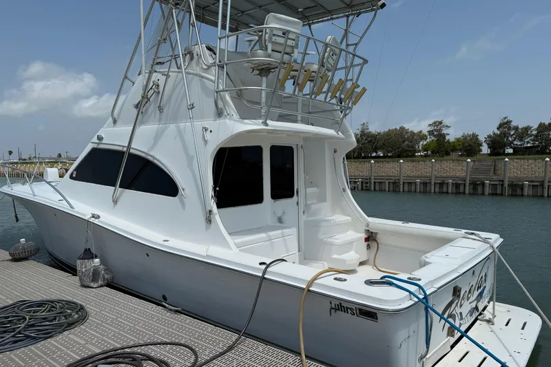 Slide: The Image of 2004 Luhrs 36 Convertible yacht docked at marina, featuring flybridge and fishing equipment. - 3