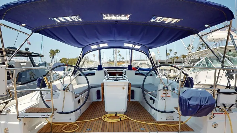 Slide: The Image of Cockpit of 2021 Beneteau Oceanis 40.1 sailboat with dual steering wheels and blue canopy. - 19