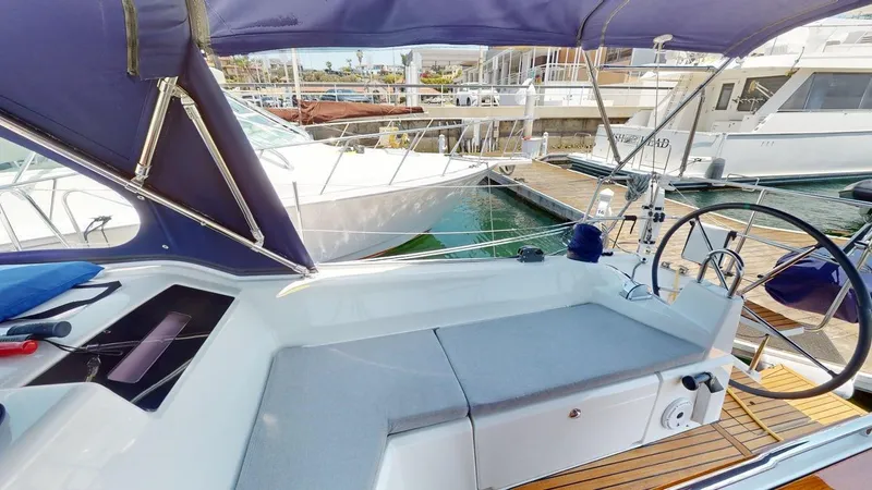 Slide: The Image of 2021 Beneteau Oceanis 40.1 yacht cockpit with seating, steering wheel, and marina view. - 4