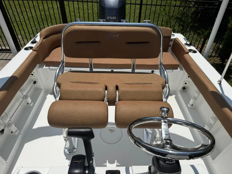 Slide: The Image of 2021 Sea Hunt Ultra 219 boat interior with tan seating and steering wheel. - 11