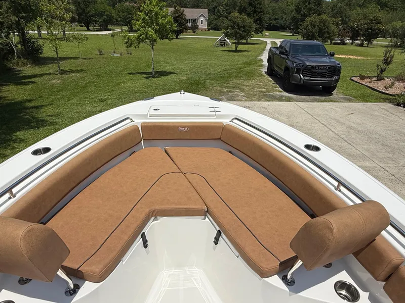 Slide: The Image of 2021 Sea Hunt Ultra 219 boat with tan seating, parked in a driveway. - 15