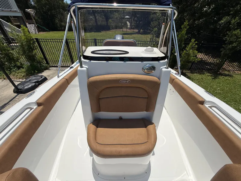 Slide: The Image of 2021 Sea Hunt Ultra 219 boat interior with tan seating and console. - 16