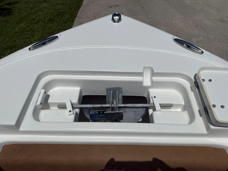 Slide: The Image of 2021 Sea Hunt Ultra 219 boat anchor compartment, open and empty, with a clear view of fittings. - 17