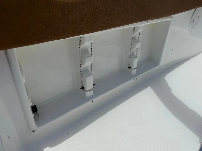 Slide: The Image of 2021 Sea Hunt Ultra 219 boat storage compartment with white interior and brown trim. - 20