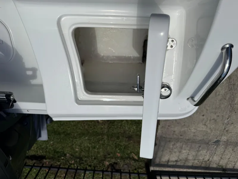 Slide: The Image of 2021 Sea Hunt Ultra 219 boat compartment with open hatch and handle. - 22