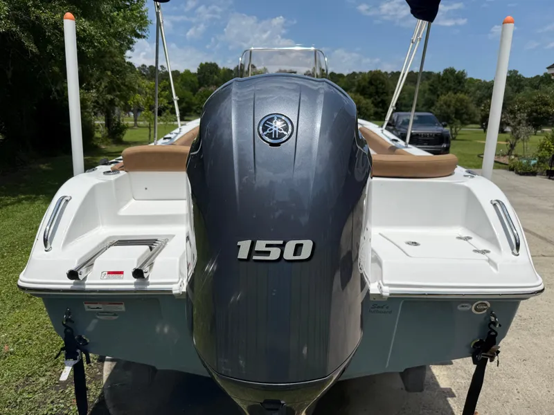 Slide: The Image of 2021 Sea Hunt Ultra 219 boat with Yamaha 150 engine, parked outdoors. - 5