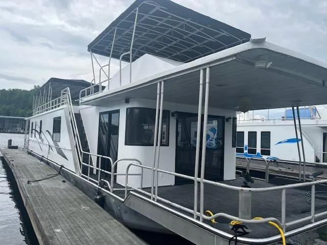 The Image of 1992 Lakeview houseboat docked, featuring upper deck and covered patio area. - 0