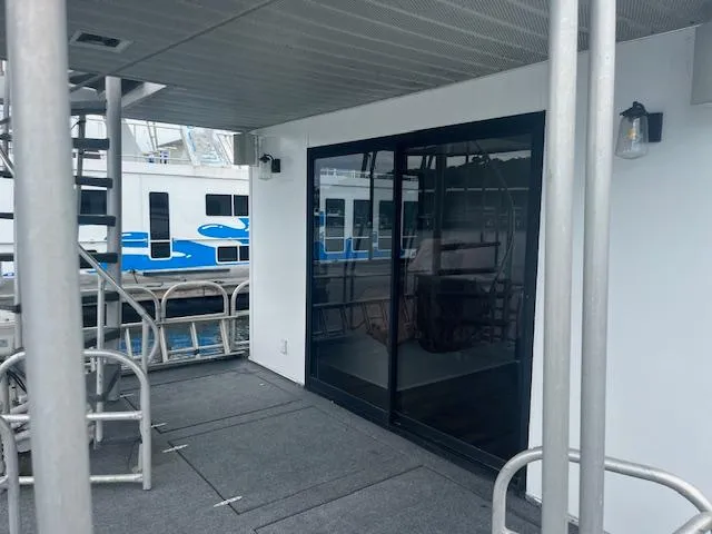 Slide: The Image of 1992 Lakeview houseboat deck with sliding glass door and metal railings. - 16