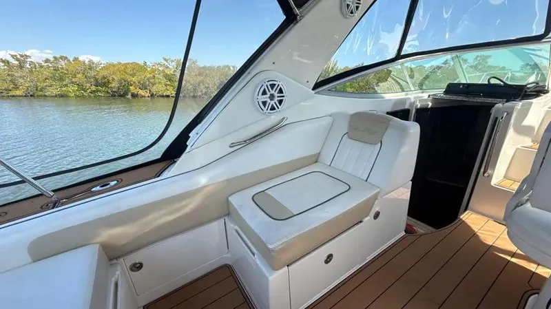 Slide: The Image of 2010 Sea Ray 310 Sundancer interior with white seating and wood flooring. - 11