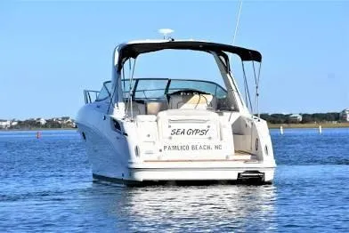 Slide: The Image of 2010 Sea Ray 310 Sundancer boat on calm water, rear view, clear sky. - 4