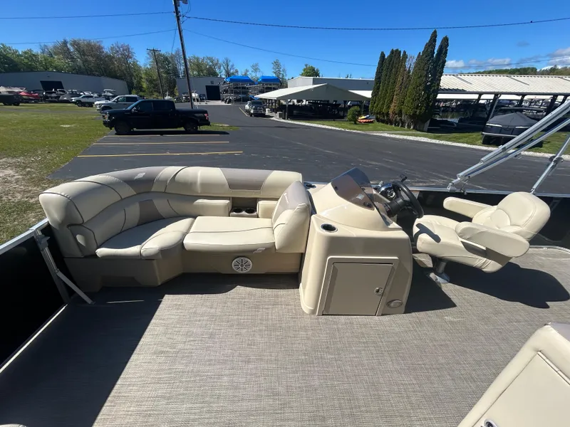 Slide: The Image of 2019 Starcraft EX 20 C pontoon boat interior with beige seating and steering console. - 12