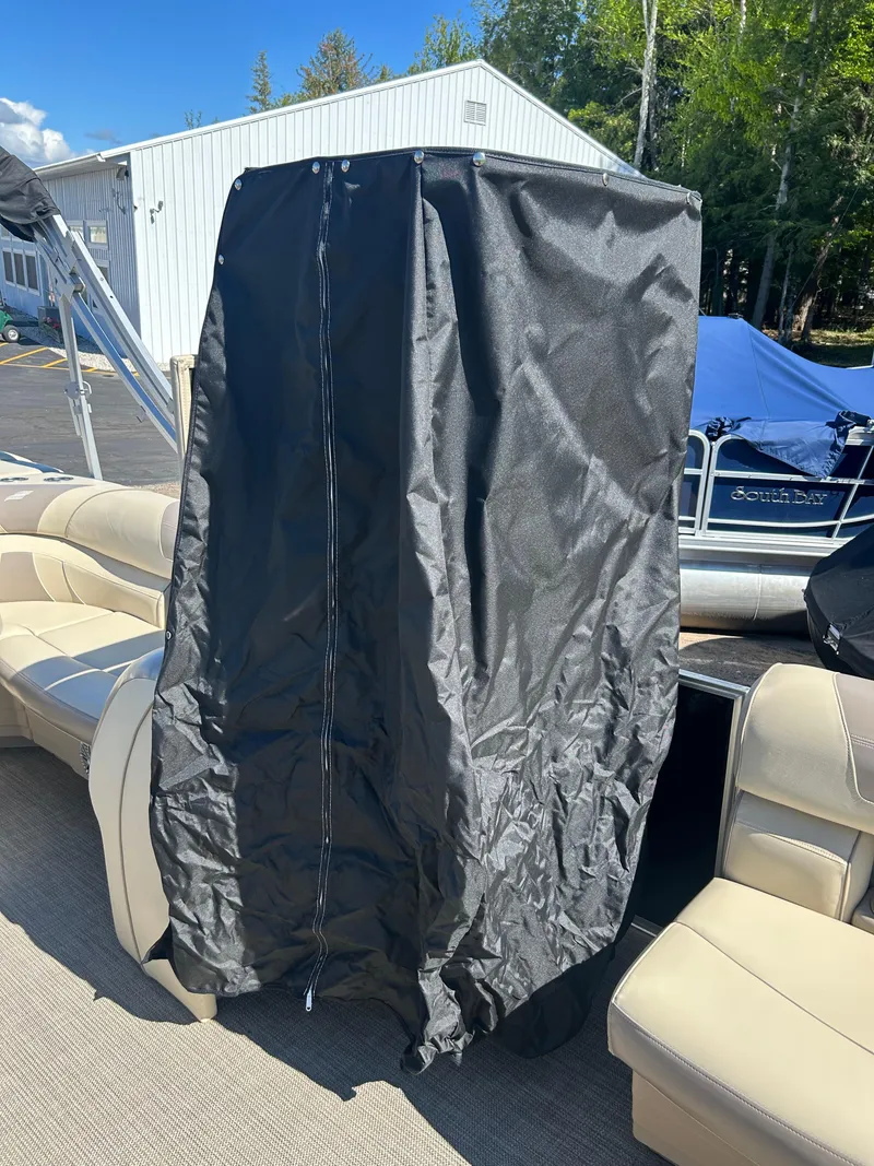 Slide: The Image of 2019 Starcraft EX 20 C boat with black cover, beige seating, and outdoor setting. - 13