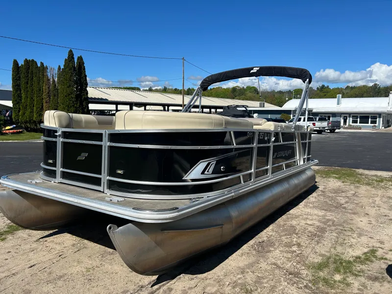 Slide: The Image of 2019 Starcraft EX 20 C pontoon boat with beige seating, parked outdoors under a clear blue sky. - 4