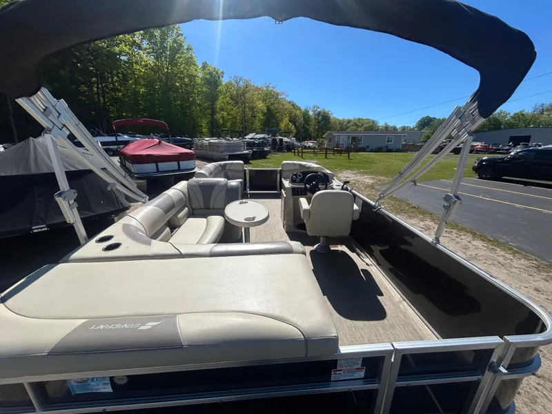 Slide: The Image of 2019 Starcraft EX 20 C pontoon boat with seating and canopy in a sunny outdoor setting. - 5