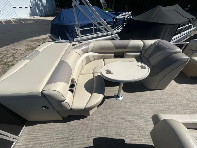 Slide: The Image of 2019 Starcraft EX 20 C pontoon boat interior with beige seating and round table. - 6