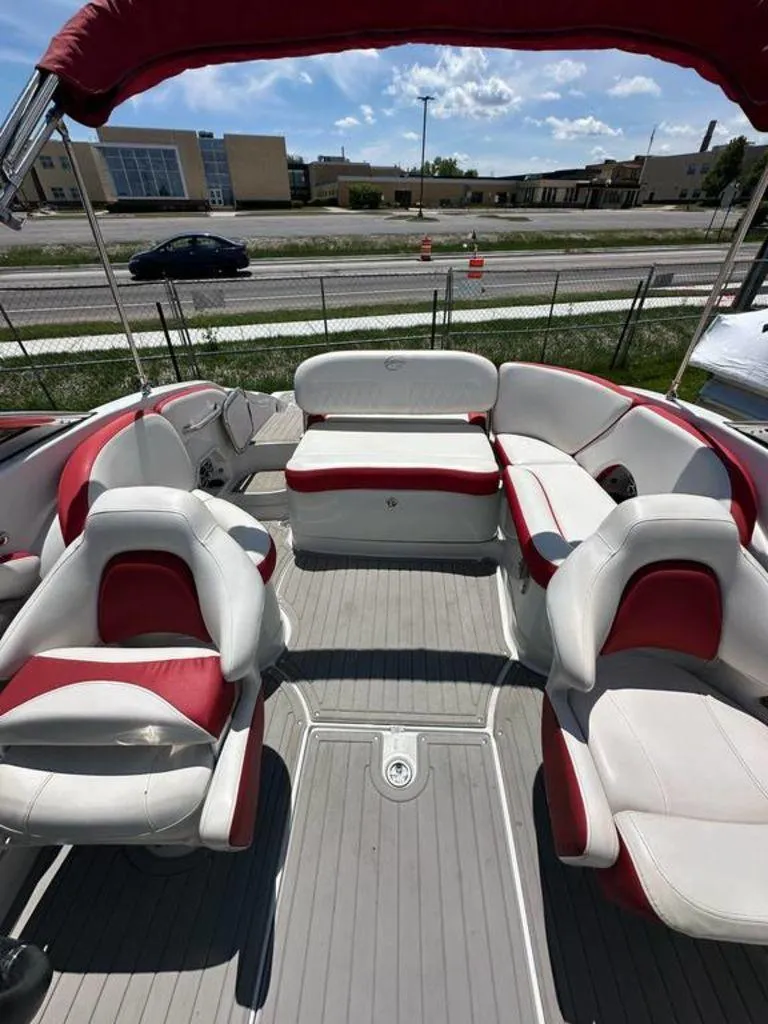 Slide: The Image of 2017 Crownline E2 boat interior with red and white seating, under a sunny sky. - 13