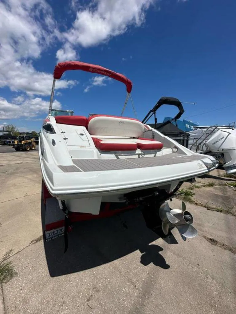 Slide: The Image of 2017 Crownline E2 boat with red accents, parked outdoors under a blue sky. - 17