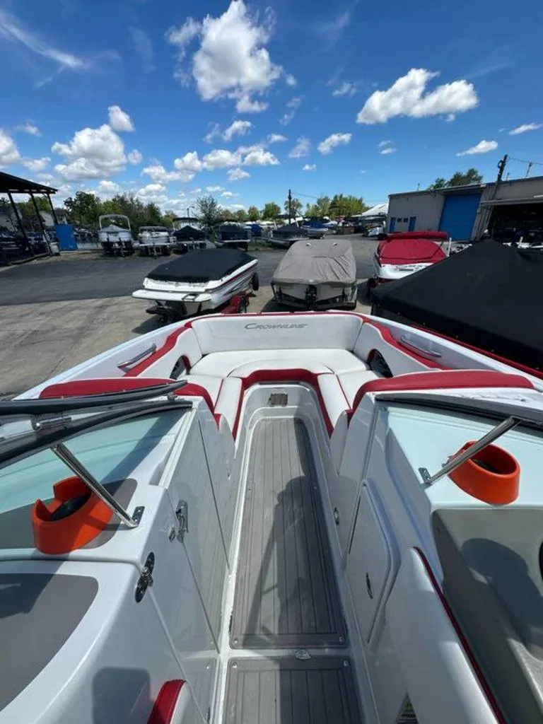 Slide: The Image of 2017 Crownline E2 boat interior with red and white seating, docked under a blue sky. - 3