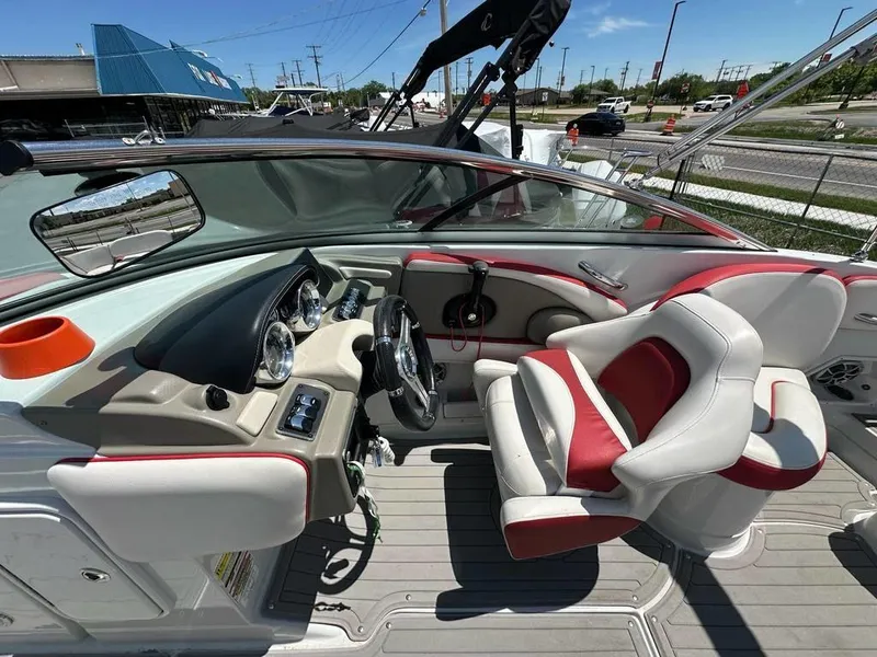 Slide: The Image of 2017 Crownline E2 boat interior with red and white seating, dashboard, and steering wheel. - 8