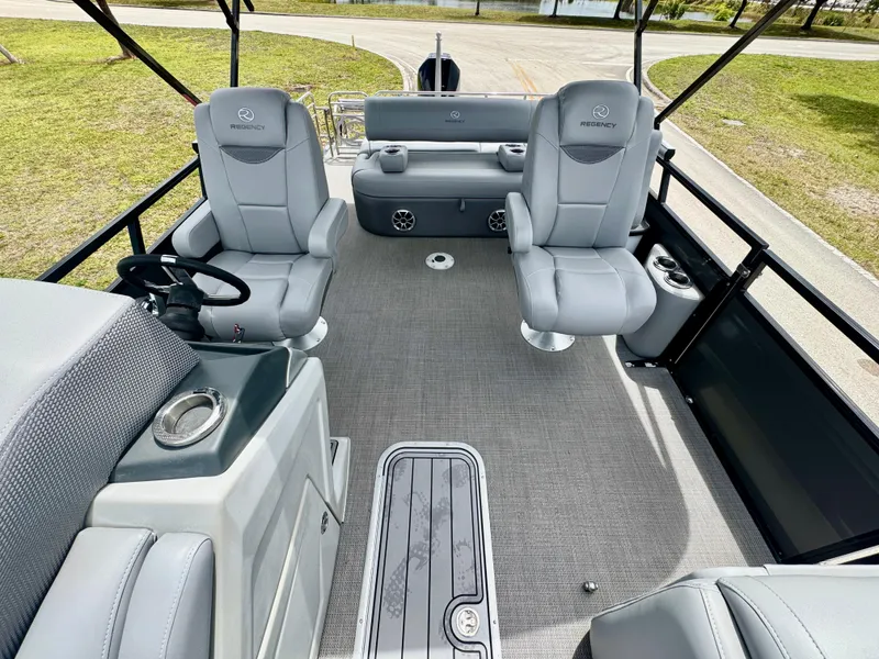 Slide: The Image of 2022 Regency 230 LE3 Sport boat interior with gray seating and steering console. - 12