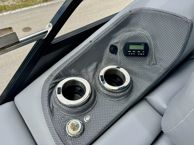 Slide: The Image of 2022 Regency 230 LE3 Sport boat console with cup holders and control panel. - 23