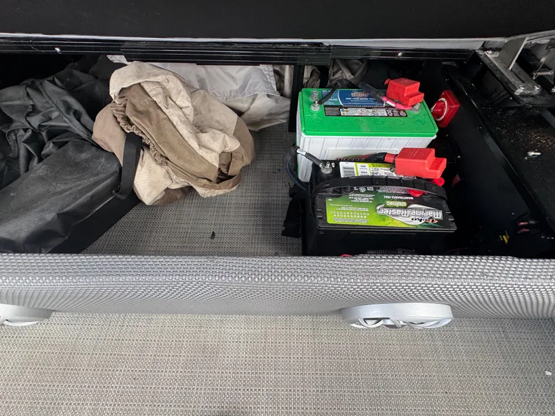 Slide: The Image of Storage compartment with batteries and fabric in a 2022 Regency 230 LE3 Sport boat. - 26