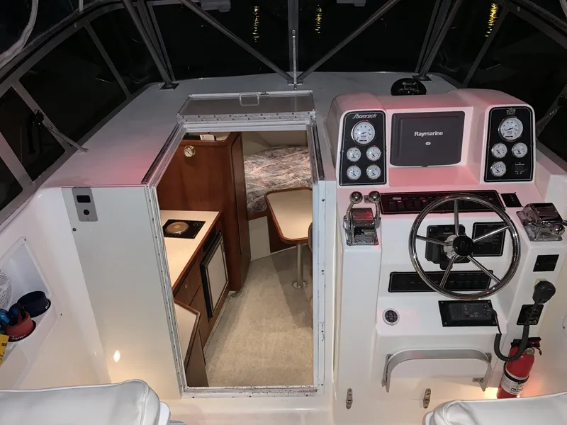 Slide: The Image of 2000 Shamrock 290 Walkaround boat interior with steering console and cabin view. - 3