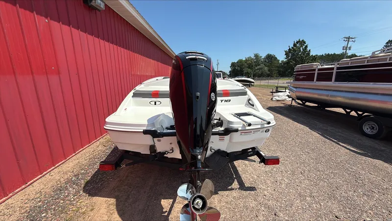 Slide: The Image of 2025 Tahoe T18 boat with outboard motor, parked near a red building. - 4