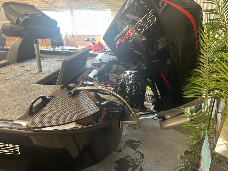 Slide: The Image of 2025 Tracker Savage 215 boat with Mercury Pro XS engine in a garage setting. - 12