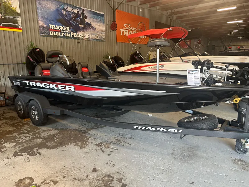 Slide: The Image of 2025 Tracker Savage 215 boat in showroom, black with red accents, on trailer. - 7