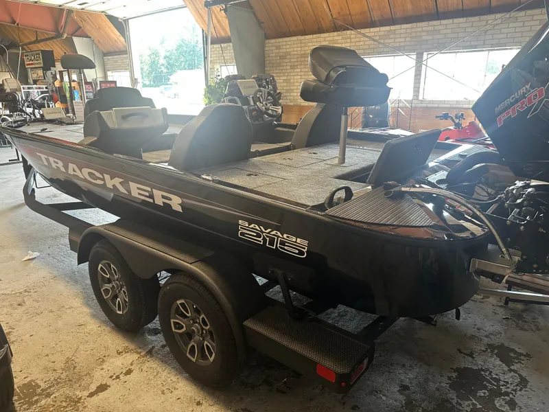 Slide: The Image of 2025 Tracker Savage 215 boat on trailer in indoor showroom setting. - 8