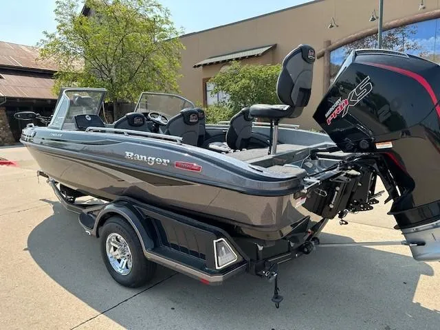 Slide: The Image of 2025 Ranger 1880MS boat with motor, parked outdoors on a sunny day. - 2