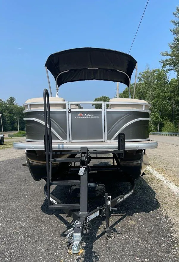 Slide: The Image of 2025 Sun Tracker Party Barge 20 DLX pontoon boat on trailer, parked outdoors. - 3