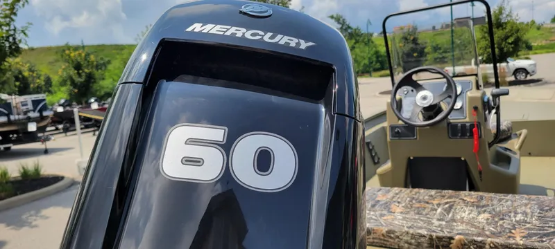 Slide: The Image of 2025 Tracker Grizzly 1860 CC boat with Mercury 60 engine, parked outdoors. - 3