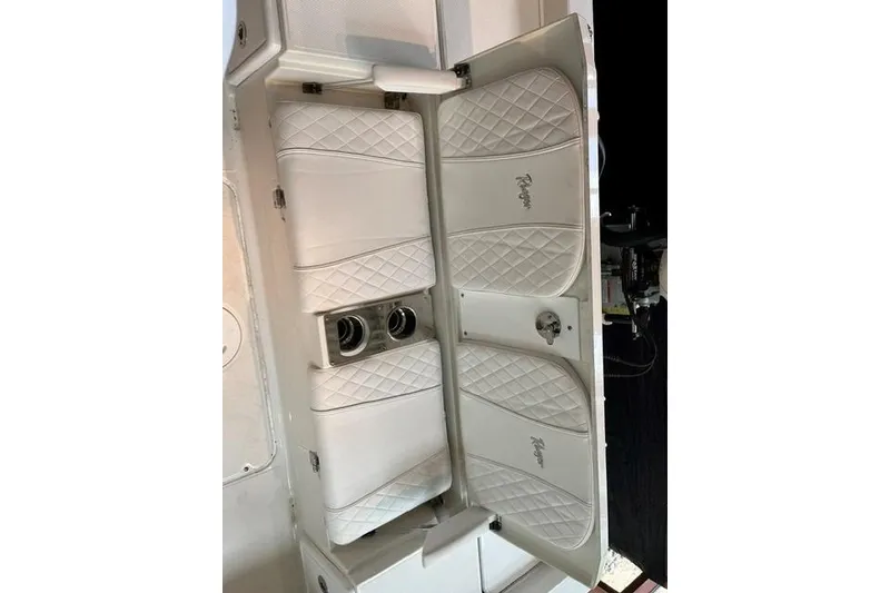 Slide: The Image of 2025 Ranger 2510 Bay boat interior with white quilted seats and cup holders. - 12
