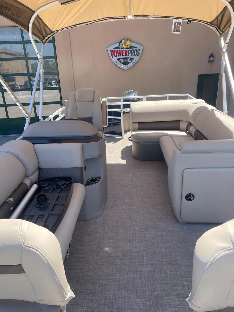 Slide: The Image of 2025 Sun Tracker Fishin' Barge 20 DLX interior with beige seating and canopy. - 3