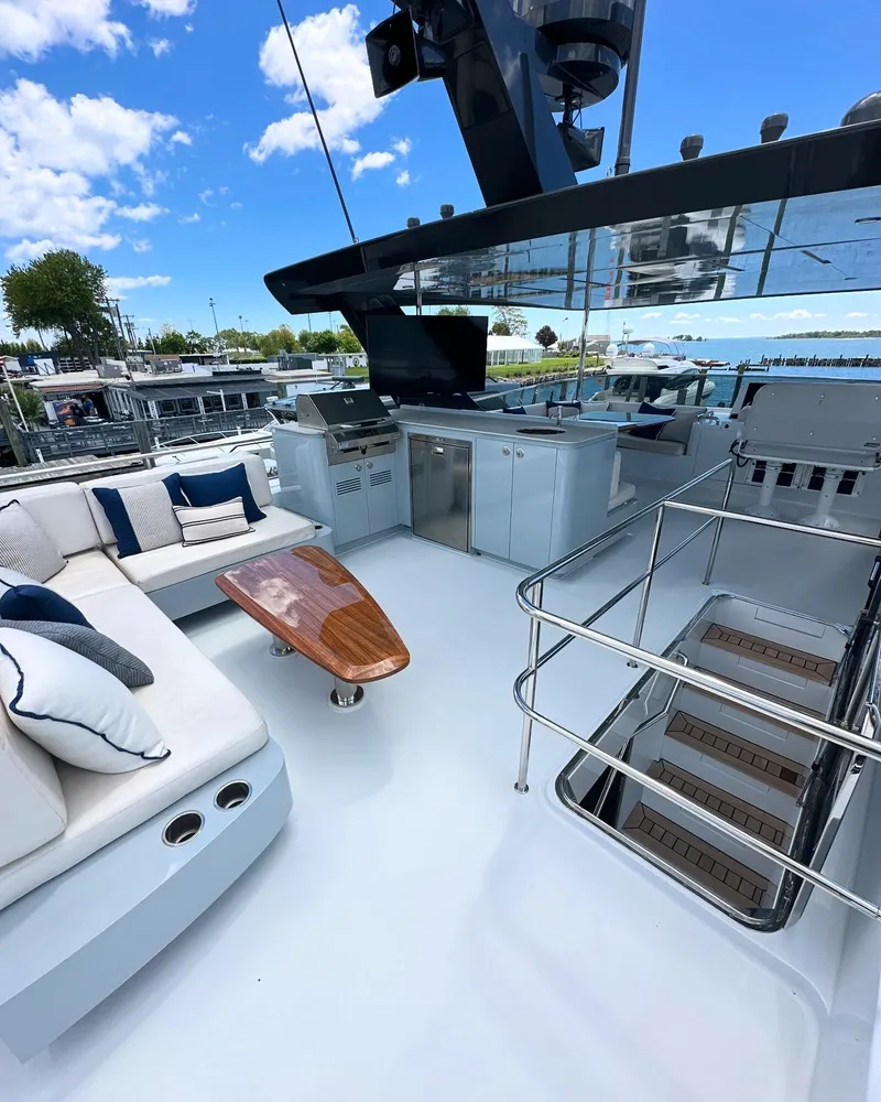 Slide: The Image of Luxurious 2023 CL Yachts CLB65 deck with seating, table, and stairs under a clear blue sky. - 12