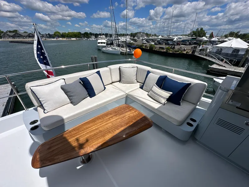 Slide: The Image of Luxurious 2023 CL Yachts CLB65 yacht deck with elegant seating and scenic marina view. - 13