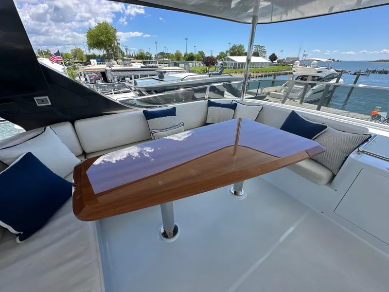 Slide: The Image of Luxurious seating area on 2023 CL Yachts CLB65 with elegant wooden table and waterfront view. - 18