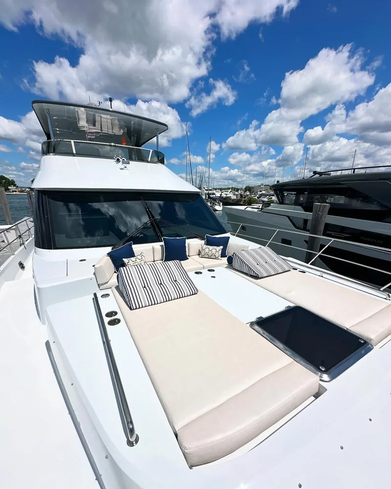 Slide: The Image of 2023 CL Yachts CLB65 luxury yacht with sunbathing area, docked under a vibrant blue sky. - 20