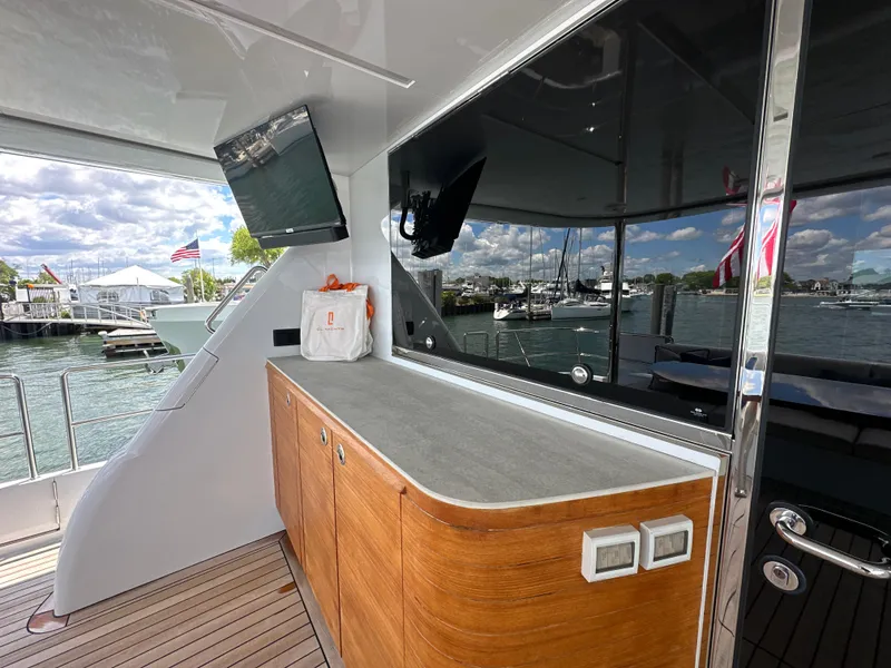 Slide: The Image of 2023 CL Yachts CLB65 yacht deck with wooden cabinetry and marina view. - 7
