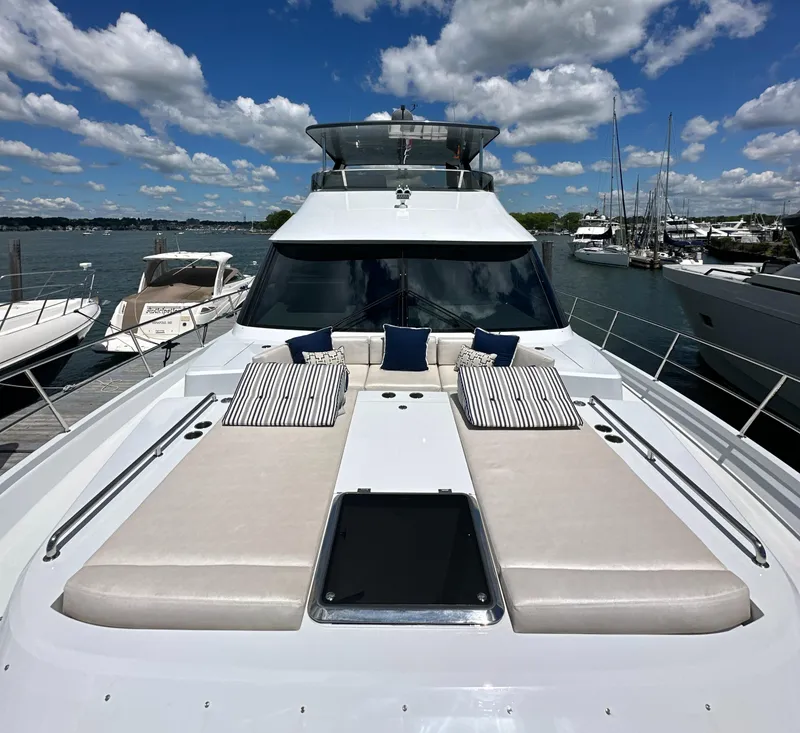 Slide: The Image of 2023 CL Yachts CLB65 luxury yacht with sun loungers, docked under a blue sky. - 19