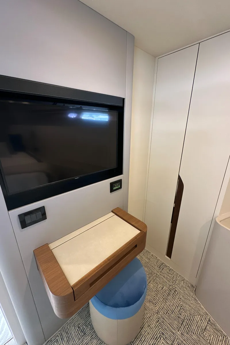 Slide: The Image of 2023 CL Yachts CLB65 interior with TV, modern desk, and storage. - 40