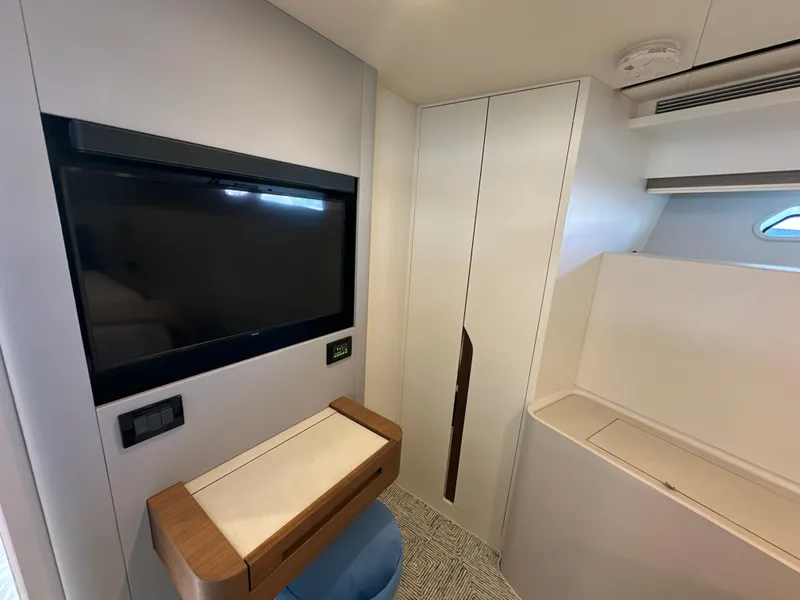 Slide: The Image of 2023 CL Yachts CLB65 interior with modern TV, sleek cabinetry, and compact workspace. - 41