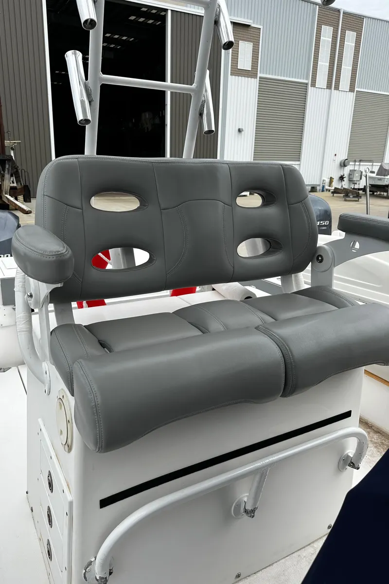 Slide: The Image of 2005 Regulator 32 FS boat seat with gray upholstery, docked near industrial buildings. - 11