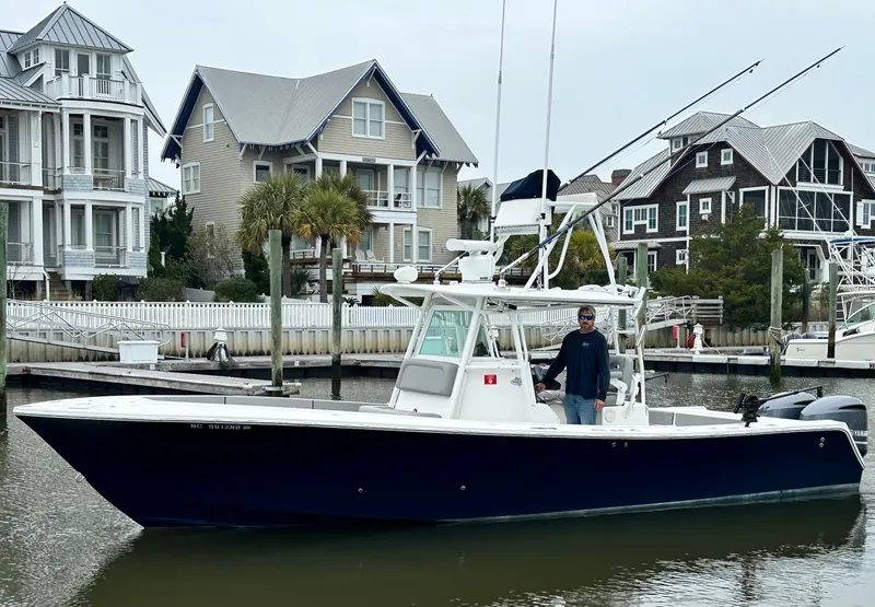 Slide: The Image of 2005 Regulator 32 FS boat docked near waterfront homes. - 2