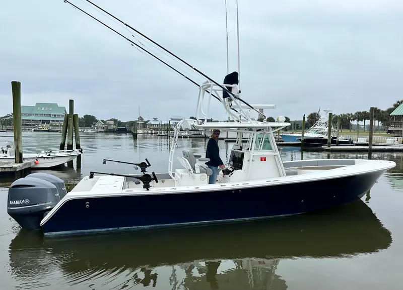 Slide: The Image of 2005 Regulator 32 FS boat docked in a marina, featuring dual outboard engines. - 3