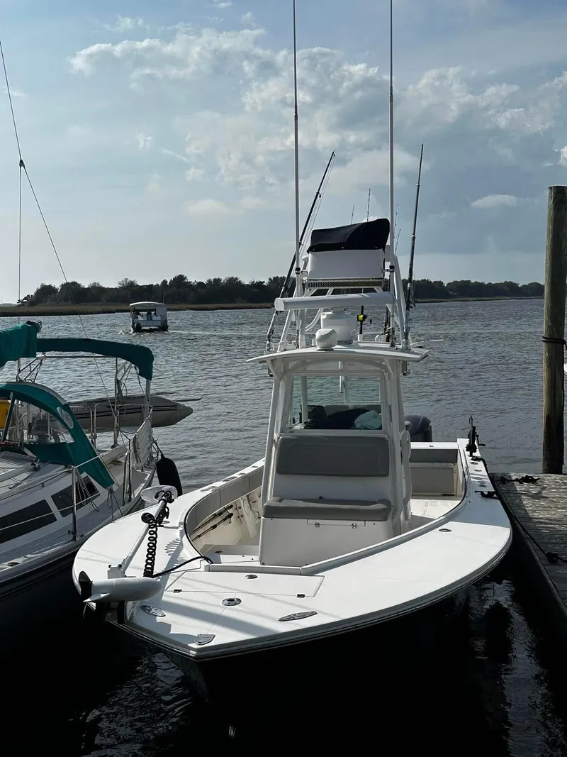 Slide: The Image of 2005 Regulator 32 FS boat docked by the water on a sunny day. - 4